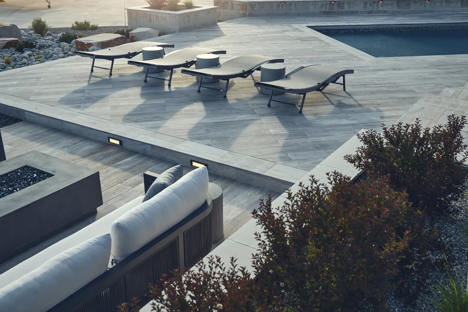 Elevated view of the paver deck, chaise lounges, pool corner, and sunken lounge