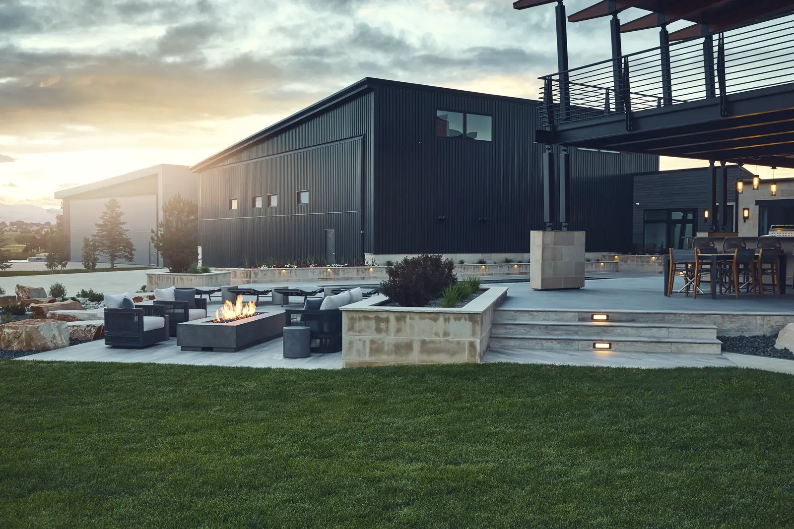 Lawn and fire pit lounge in front of the modern home at sunset